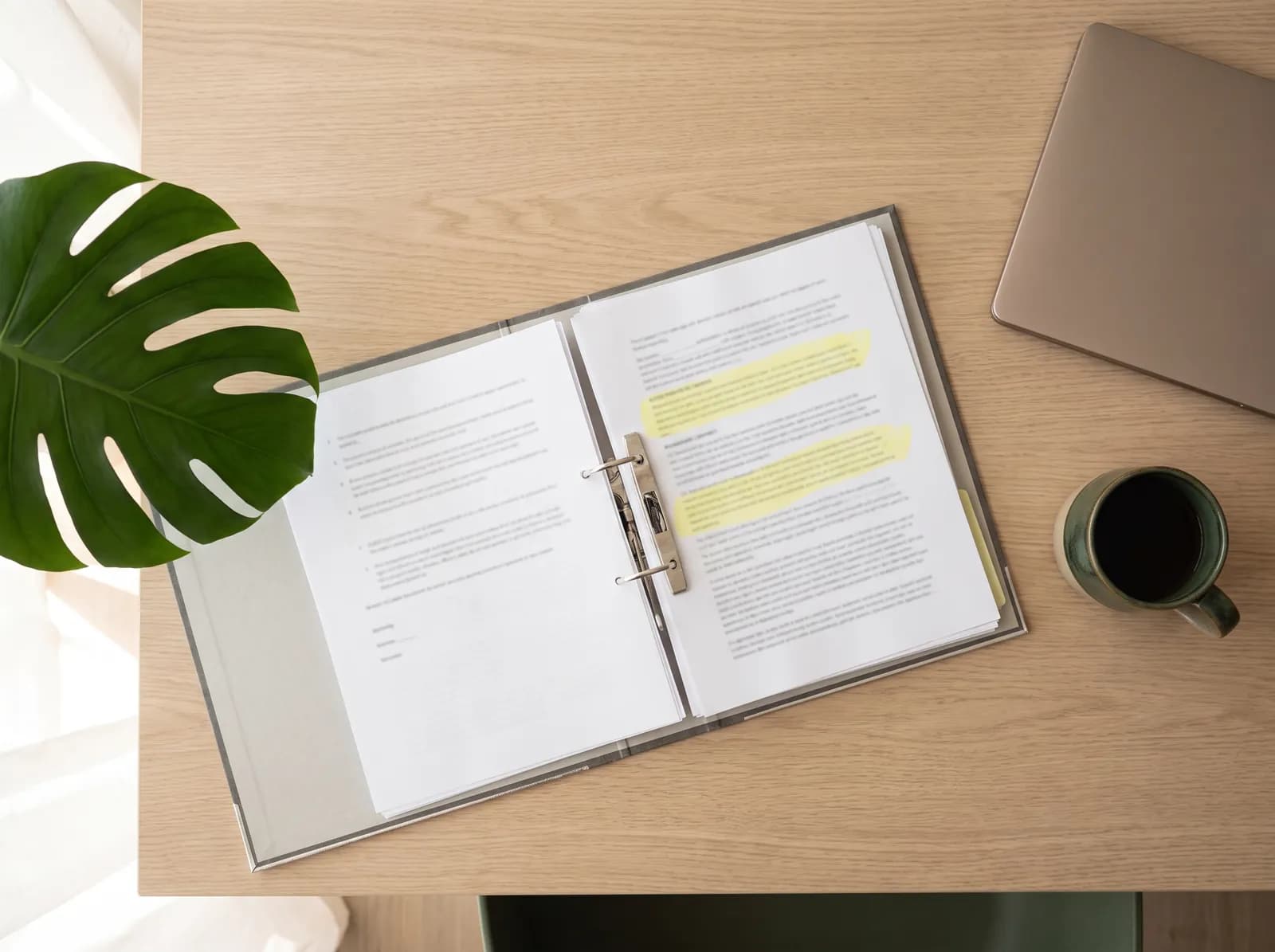 Aufgeschlagener Ordner mit Vertragsseiten, einzelne Stellen mit Textmarker markiert